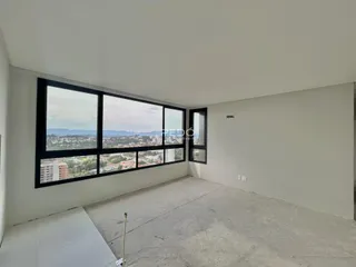 Ambiente interno com grande janela oferecendo vista da paisagem urbana.