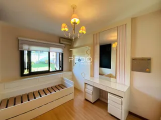 Sala de estar com banco de janela e piso de madeira clara.