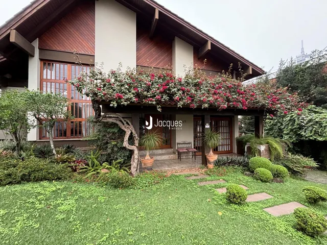 Fachada de uma residência em Lajeado, Brasil, com jardim exuberante e vegetação.