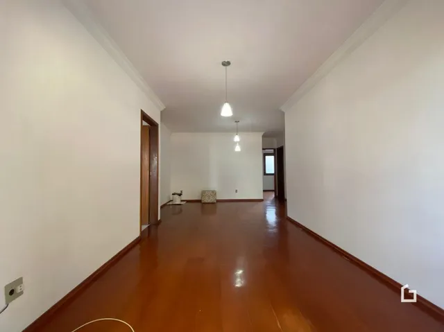 Corredor interno com piso de madeira polida.