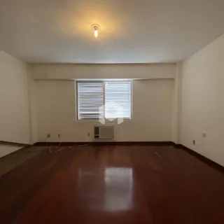 Sala de estar com piso de madeira e janela.