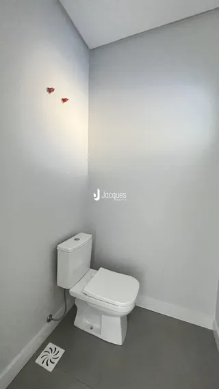 A foto mostra uma área de banheiro com um vaso sanitário branco.