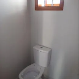 Foto de um vaso sanitário branco em um ambiente.