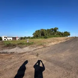 Vista de uma estrada de terra seca sob um céu azul claro.