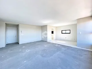Interior de um espaço vazio com paredes brancas e piso de concreto