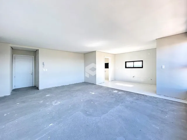 Interior de um espaço vazio com paredes brancas e piso de concreto