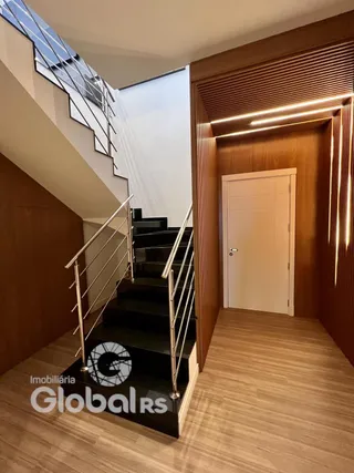 Hall de entrada com escadaria e portas em madeira.