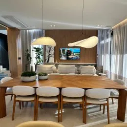 Uma mesa de madeira com cadeiras em um ambiente interno.