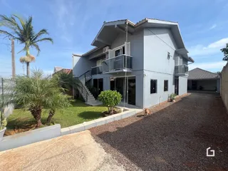 Fachada de uma casa em Lajeado, Brasil com jardim e garagem.