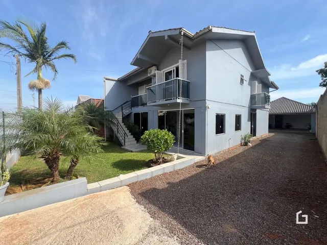 Fachada de uma casa em Lajeado, Brasil com jardim e garagem.