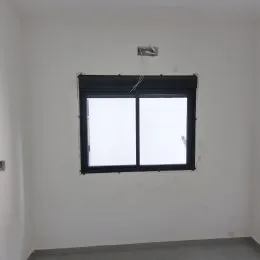 Foto de uma parede branca com uma janela.