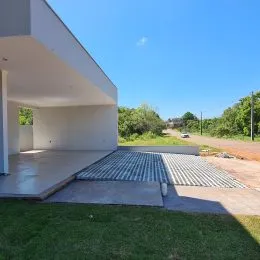 Área externa com gramado e piso de concreto em uma residência.