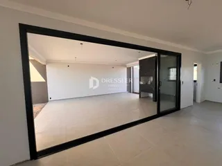 Vista interna de uma sala ampla com piso de cerâmica clara.