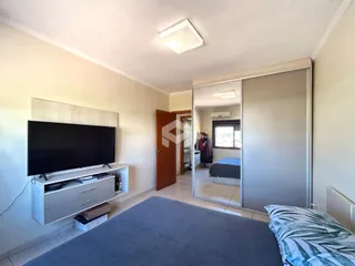 Quarto com cama e televisão em um apartamento.