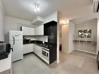 Foto de uma cozinha moderna com armários brancos e bancadas escuras.