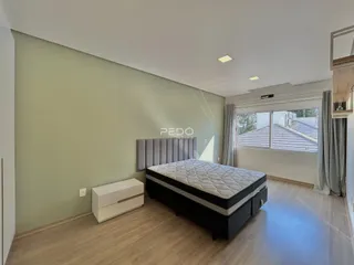 Quarto com cama e armário em sala de estar.