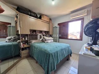 Quarto com cama e armários de madeira em um imóvel no Brasil.