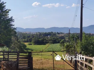Uma vista externa mostrando um campo verde e vegetação ao redor da propriedade.