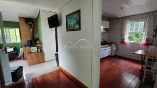 Sala de estar com piso de madeira e janela em imóvel em Lajeado.