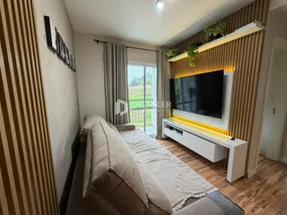 Sala de estar com sofá e televisão em um apartamento no Brasil.