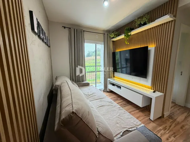Sala de estar com sofá e televisão em um apartamento no Brasil.