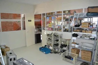 Interior com paredes de tijolo aparente e estantes de metal no ambiente.