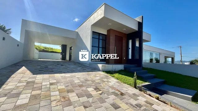 Fachada de uma casa moderna em Lajeado, Brasil, com área externa pavimentada e paisagismo.