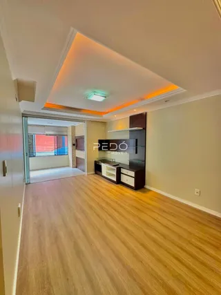Sala de estar com piso de madeira e teto embutido.