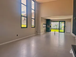 Ambiente interno com grandes janelas e piso claro.