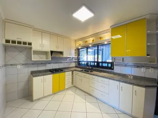 Cozinha com armários brancos e bancadas de granito em Lajeado.