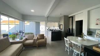 Uma sala de estar ampla com sofá e mesa de jantar em um apartamento.