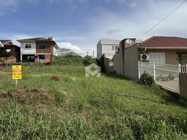 Vista externa de casas em Lajeado, Brasil, com terreno com vegetação alta.