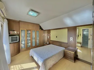 Quarto com armários de madeira e cama em um imóvel no Brasil.