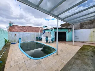 Piscina externa com deck e estrutura de pérgola.