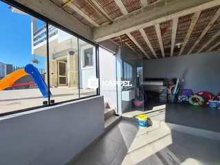Vista de um ambiente interno com acesso a uma área externa com playground.