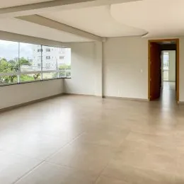 Sala ampla com piso claro e grande janela.