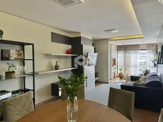 Sala de estar com decoração moderna e estantes de madeira.