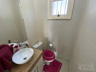 Foto interna de um banheiro mostrando a pia e o vaso sanitário.