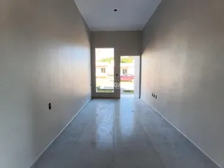 Corredor interno de uma residência com paredes brancas e piso claro.