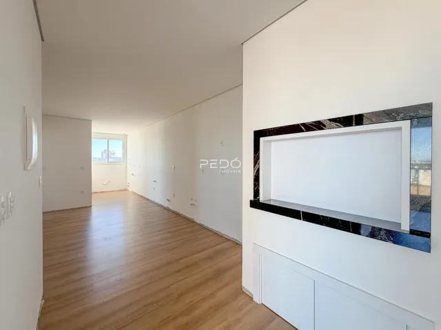 Corredor interno de uma residência com piso de madeira clara.
