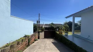 Fachada de uma residência em Lajeado, Brasil, com muro e portão de madeira.