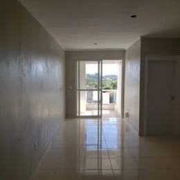 Hall de entrada com piso claro e porta de vidro que dá para o exterior.