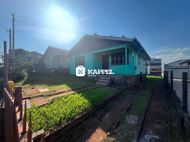 Fachada de uma casa em Lajeado, Brasil, com pintura verde-água e jardim frontal.