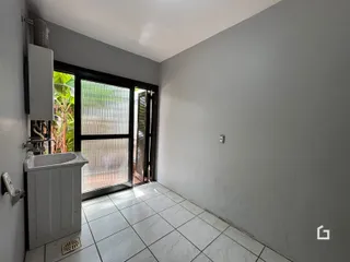 Vista interna de uma parede com janela e piso de cerâmica em um imóvel no Brasil.