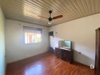 Sala de estar com piso de madeira e teto com painéis
