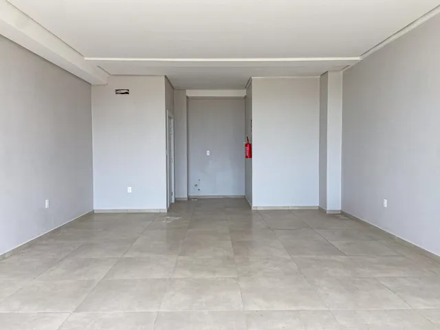 Foto de um corredor interno com paredes brancas e piso de cerâmica.