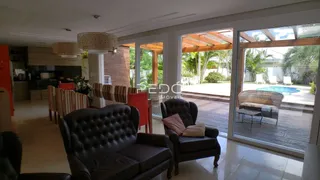 Sala de estar com vista para o pátio e piscina de uma residência em Lajeado.