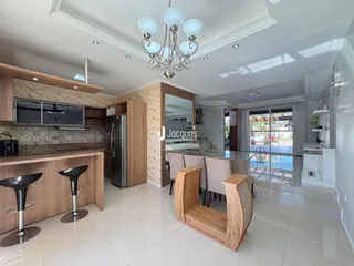 Sala de estar moderna com cozinha integrada e piso de cerâmica clara.