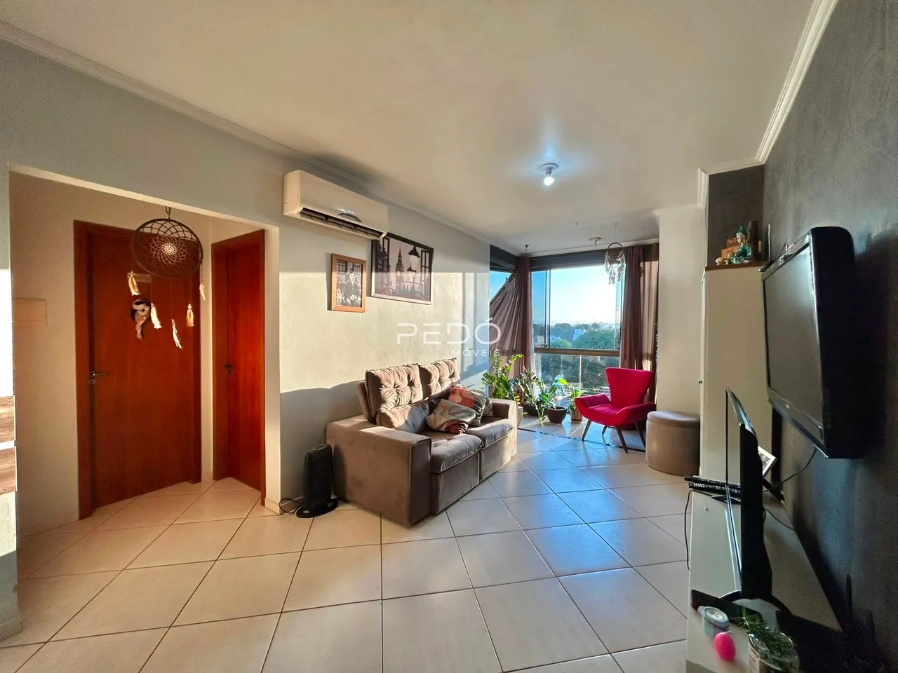 Sala de estar com piso de cerâmica e portas de madeira em um imóvel no Brasil.