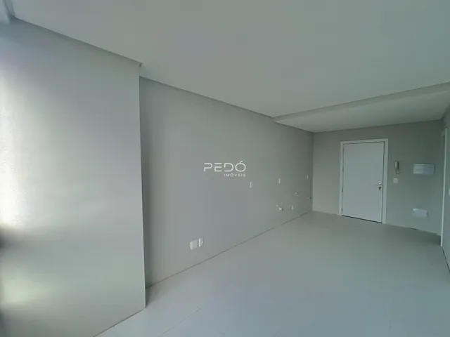 Hall de entrada com paredes brancas e piso claro.